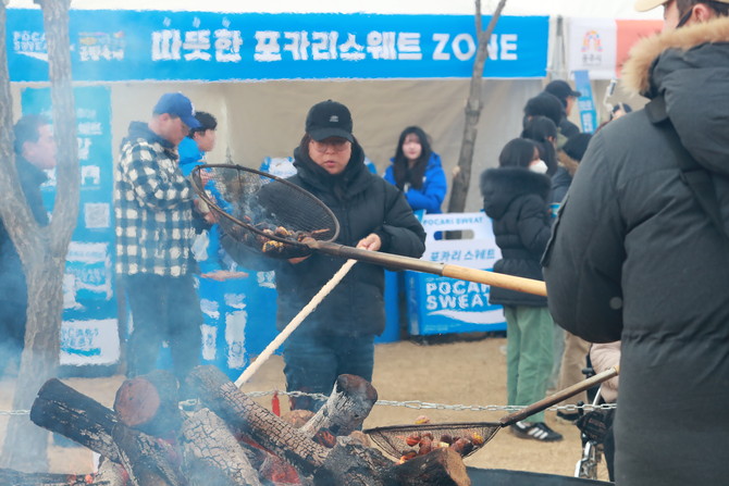 지난 16일 충남 공주시 금강신관공원 일원에서 열린 '제8최 겨울공주 군밤축제' 현장. 축제 참관객들이 직접 대형화로에서 알밤을 굽고 있다. ⓒ 동아오츠카