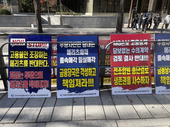 27일 보험업계에 따르면 MG손보 매각은 여전히 진전이 없는 가운데 소비자들의 불안만 늘고 있다. 사진은 정부서울청사 앞에 놓인 전국사무금융서비스 MG손보 지부의 시위 팻말. = 김정후 기자