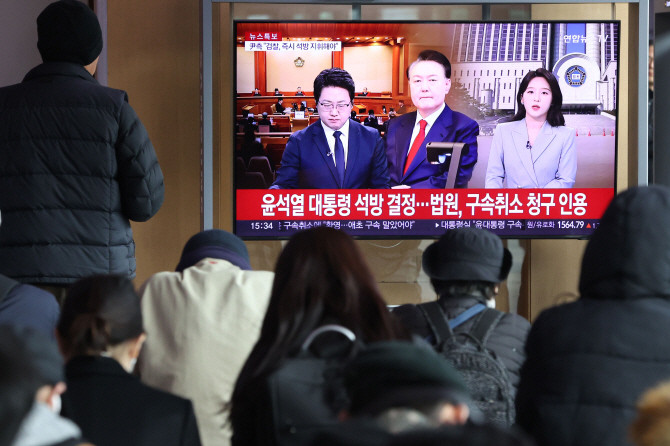 7일 서울역 대합실에서 시민들이 윤석열 대통령 구속 취소 관련 보도를 시청하고 있다. ⓒ 연합뉴스