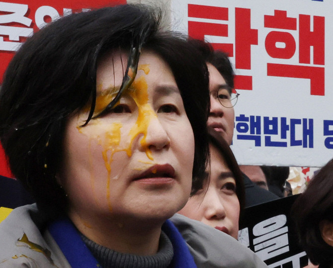 윤석열 대통령 탄핵심판 선고일 발표가 늦어지고 있는 가운데 20일 서울 종로구 헌법재판소 앞에서 기자회견에 참가 중이던 백혜련 더불어민주당 의원이 계란을 맞은 채 발언하고 있다. ⓒ 연합뉴스