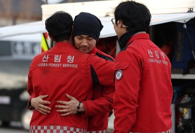 경북 산불의 주불 진화가 완료된 28일 경북 의성군 산림청 상황실 인근에서 산림청 산림항공본부 공중진화대 대원들이 산불 진화 완료를 자축하고 있다. ⓒ 연합뉴스