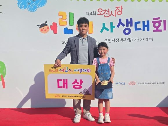 구정초등학교 2학년 도혜은 학생(오른쪽)이 영예의 대상을 차지하며 김정하 회장과 기념촬영을 하고 있다. ⓒ 최병수 기자