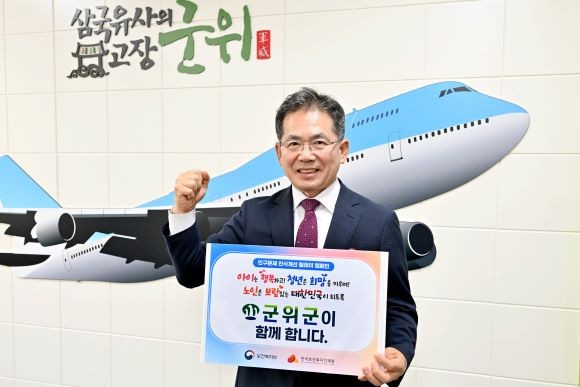인구문제 인식개선 릴레이 캠페인에 동참한 김진열 군위군수가 홍보 피켓을 들고 행사에 참여하고 있다. ⓒ 군위군