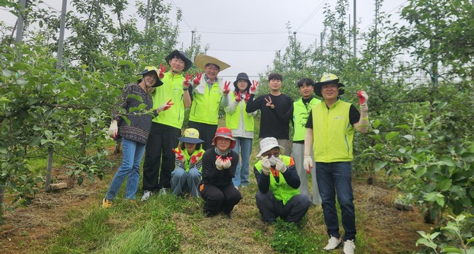 본격적인 농번기를 맞아 건축과 직원들이 지난 22일 신양면의 한 사과 농가를 찾아 농촌일손돕기 활동 후 기념촬영을 하고 있다. ⓒ 예산군