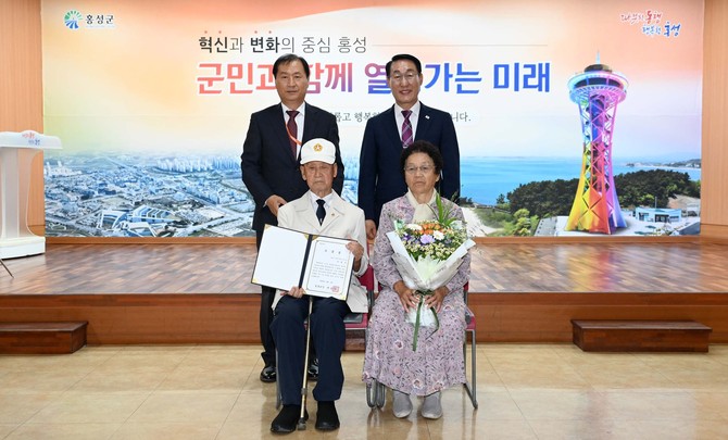 지난 2일 군청 대강당에서 열린 직원 모임에서 6·25 전쟁 참전 유공자인 이병옥 님에게 군수 표창을 전수 후 기념촬영을 하고 있다. ⓒ 홍성군