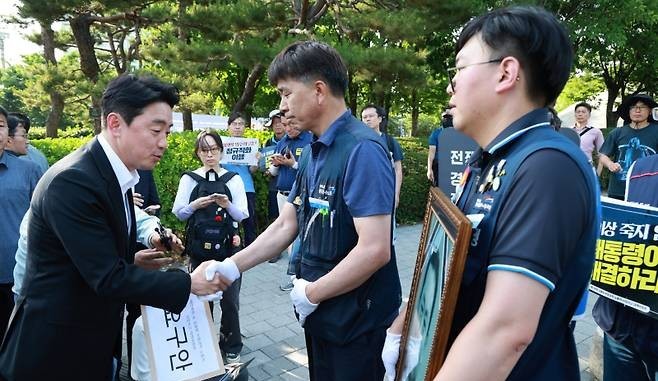 강훈식 대통령비서실장이 6일 서울 용산 대통령실 청사 인근 전쟁기념관 앞에서 태안화력발전소 사고 희생자 고(故) 김충현 씨와 관련해 엄길용 공공운수노조 위원장, 유족, 사고 대책위 관계자로부터 요구안 서한을 직접 받은 후 인사하고 있다. ⓒ 연합뉴스