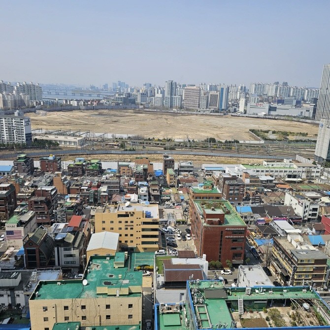 용산 국제업무지구가 들어설 코레일 철도정비창 부지(위쪽)와 정비창 전면 1구역 재개발 단지 모습. © 연합뉴스