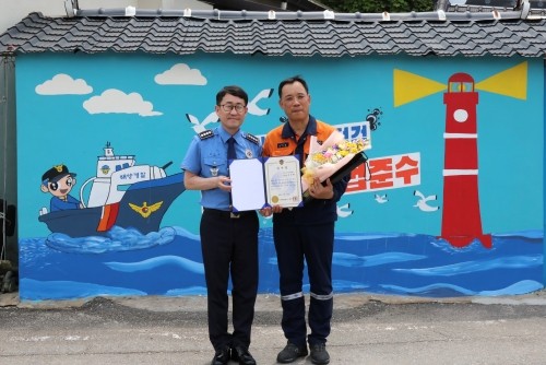 김기용 여수해양경찰서장(왼쪽)이 강성환 에버그린 벽화 재능봉사단장에게 감사장을 수여하고 기념촬영을 하고 있다. ⓒ 광양제철소