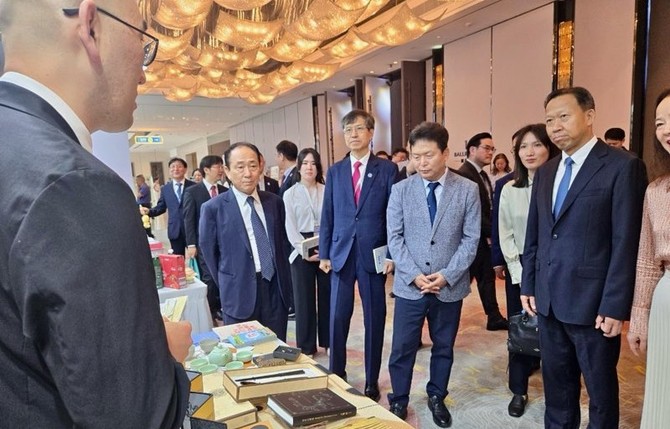 지난 17일 2025 한중일 경제 심포지엄 참석한 내빈들이 2025 청주비엔날레 홍보부스에서 청주시 직원으로부터 설명을 듣고 있다. ⓒ 청주시