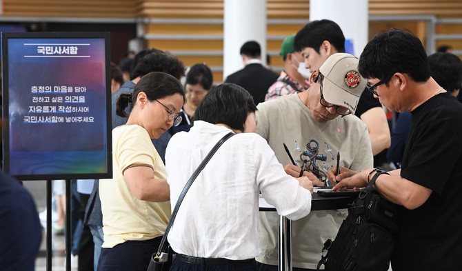 4일 대전컨벤션센터에서 열린 '충청 타운홀 미팅'에서 시민들이 국민사서함에 정책 의견을 작성하고 있다. ⓒ 한국사진기자협회 대전·충남지회 제공