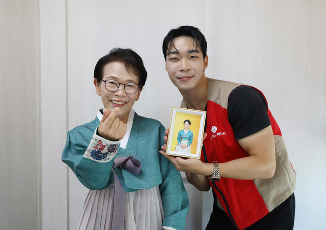 롯데이노베이트 봉사자가 행사에 참여한 어르신과 사진을 찍고 있다. ⓒ 롯데이노베이트