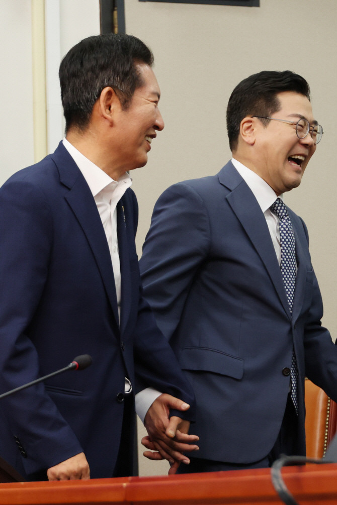 정청래·박찬대(오른쪽) 더불어민주당 당 대표 후보가 15일 서울 여의도 국회에서 공명선거 실천 서약식을 마친 뒤 손을 잡고서 대화하고 있다. ⓒ 연합뉴스