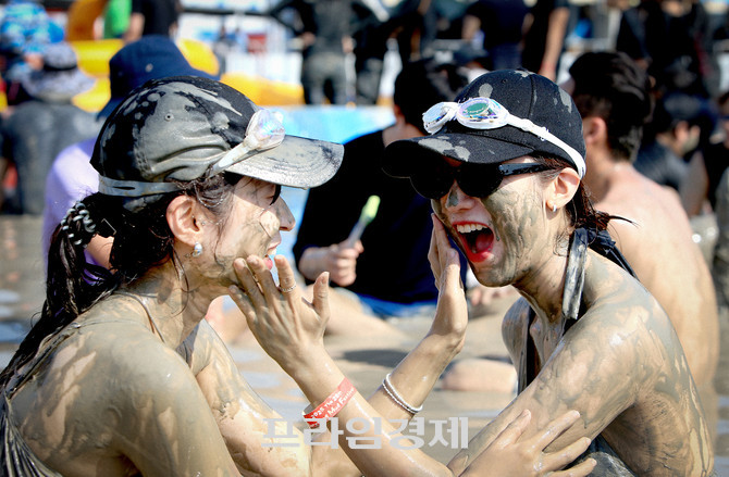제28회 보령머드축제장을 찾은 머드로 뒤덮인 얼굴에 웃음을 머금은 두 여성이 서로의 얼굴에 머드를 바르며 축제의 진한 재미를 만끽하고 있다. ⓒ 프라임경제