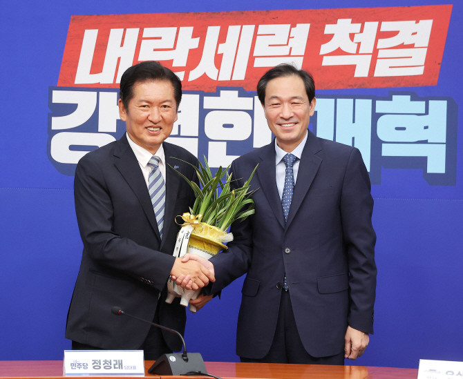 정청래 더불어민주당 대표가 4일 국회 당대표실을 예방한 우상호 대통령실 정무수석으로부터 이재명 대통령의 취임 축하 난을 받고 있다. ⓒ 연합뉴스
