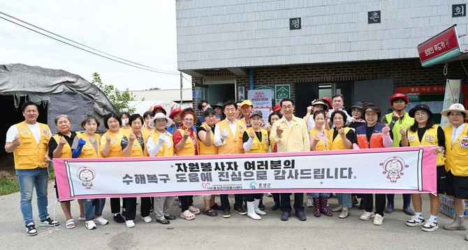 홍성군 홍북읍 일원에서 연일 이어지는 폭염에도 자원봉사자들이 침수된 비닐하우스 안 토사를 제거하며 수해 복구 작업 후 기념촬영을 하고 있다. ⓒ 홍성군