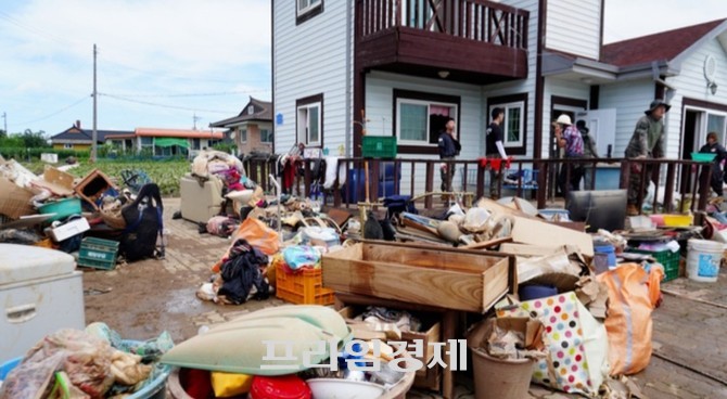 예산군 한 주택 앞에 침수 피해로 인한 쓰레기와 가재도구가 쌓여 있다. 주민들과 복구 인력들이 진흙과 폐기물을 치우며 복구 작업을 진행 중이다. ⓒ 프라임경제