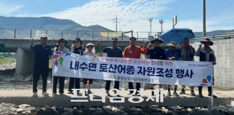 보령시 미산면 도화담리 웅천천 상류에서 '내수면 토산어종 자원조성 행사'에 참가한 충남도수산자원연구소와 보령댐 내수면어업계 관계자들이 다슬기 방류를 후 기념촬영을 하고 있다. ⓒ 프라임경제