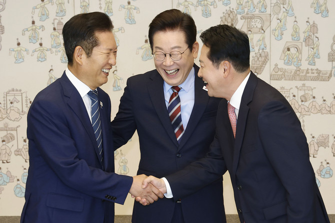 이재명 대통령이 8일 용산 대통령실에서 여야 지도부 오찬 회동에 참석한 정청래 더불어민주당 대표와 장동혁 국민의힘 대표가 악수하는 모습을 보고 있다. © 연합뉴스
