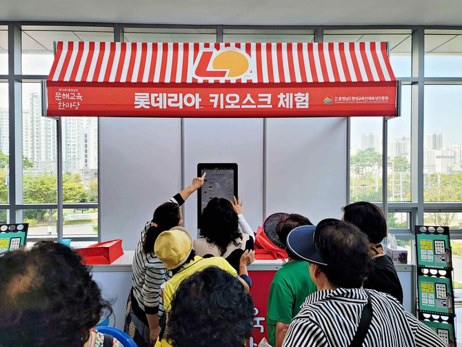 충남교육청 주관 행사 '문해한마당'에서 롯데리아 키오스크 체험을 위해 줄 서있는 고령층 고객들의 모습. ⓒ 롯데GRS