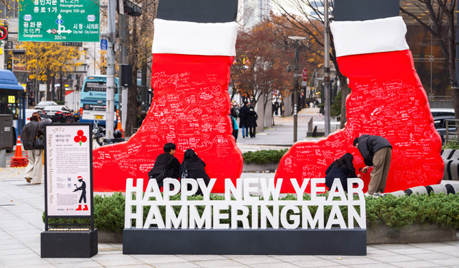 서울 광화문 랜드마크 '해머링 맨'이 사랑의열매 산타 모자를 쓰고 빨간 양말을 착용하고, 기부 캠페인을 진행중이다. ⓒ 사랑의열매