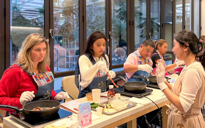 지난달 24일 더현대 서울 6층 문화센터 ‘CH 1985’에서 외국인 환승객들이 전문 강사가 진행하는 한식 쿠킹 클래스를 체험하고 있다. ⓒ 현대백화점그룹