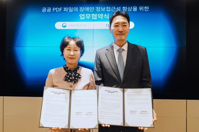 변성준 한컴그룹 부회장(오른쪽)과 황금숙 국립장애인도서관 관장이 업무협약 체결 후 기념 촬영을 하고 있다. ⓒ 한글과컴퓨터