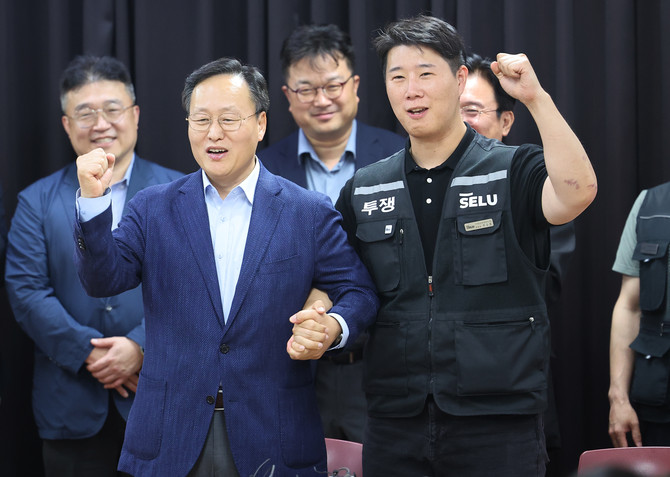 20일 경기도 수원시 장안구 경기고용노동청에서 열린 삼성전자 임금협상을 마친 후 여명구 삼성전자 DS(디바이스솔루션·반도체 사업 담당) 피플팀장과 최승호 삼성그룹 초기업노동조합 삼성전자지부 위원장이 잠정 합의안에 서명한 후 파이팅을 외치고 있다. ⓒ 연합뉴스