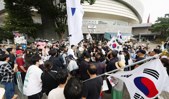 6.3 지방선거 투표용지 부족 사태를 규탄하는 시위대가 서울 송파구 올림픽공원 핸드볼경기장 앞에서 경기장에 입주한 체육단체 직원들의 출입 허용 여부와 관련해 의견을 나누고 있다. ⓒ 연합뉴스