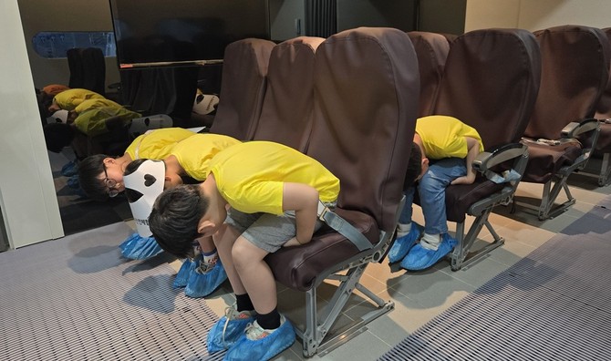 교육받은 충격방지자세를 취해보는 어린이 참가자들. ⓒ 에어로케이항공