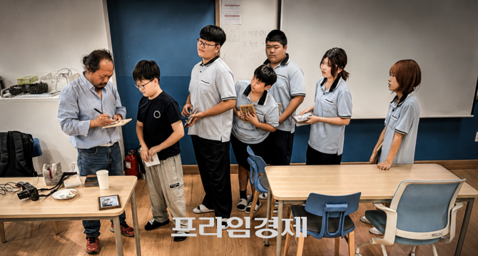 학생들이 자신의 사진을 소중히 품에 안고 백승휴 작가의 사인을 받고 있다. ⓒ =오영태 기자