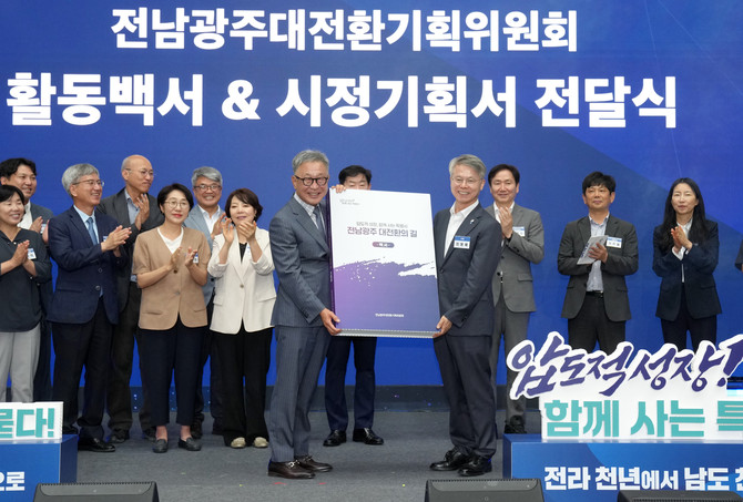 민형배 전남광주통합특별시장이 20일 무안청사 왕인실에서 열린 ‘전남광주대전환기획위원회 해단 및 활동성과 공유회’에서 정은승 위원장으로부터 기획위원회 활동백서를 전달받고 기념촬영을 하고 있다. ⓒ 기획위원회