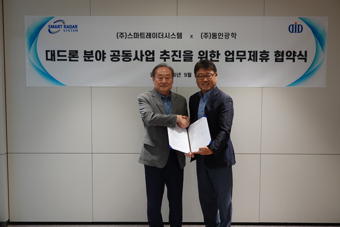 정인 동인광학 회장(왼쪽)과 김용환 스마트레이더시스템 대표이사가 업무협약을 체결하고 기념 촬영을 하고 있다. ⓒ 스마트레이더시스템