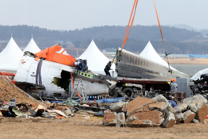 지난해 1월 제주항공 참사 현장에서 항공철도사고조사위원회 관계자들이 기체 잔해를 수습하고 있다. ⓒ 연합뉴스