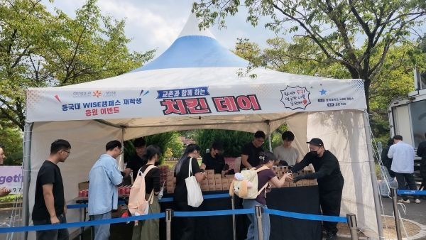 2학기 개강을 맞은 동국대 WISE캠퍼스 재학생들이 교내 용맹로에서 열린 치킨 나눔 행사에 참여해 치킨을 전달받고 있다. ⓒ 동국대학교 WISE캠퍼스