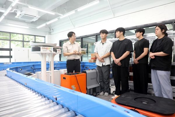 성금길 교수가 영남이공대학교 AI물류교육센터에서 학생들에게 AI 기반 물류자동화 시스템의 운영 원리와 주요 설비의 기능을 설명하고 있다. 학생들은 실제 물류현장에서 활용되는 자동화 장비를 직접 살펴보며 물류설비 운용과 유지보수 등 현장 실무 역량을 키우고 있다. ⓒ 영남이공대학교