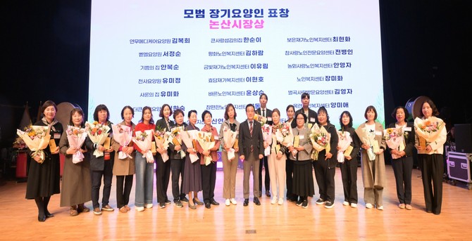 지난 27일 오후 논산아트센터 대공연장에서 '2026년 장기요양인의 날' 행사를 공동 개최 후 기념촬영을 하고 있다. ⓒ 논산시