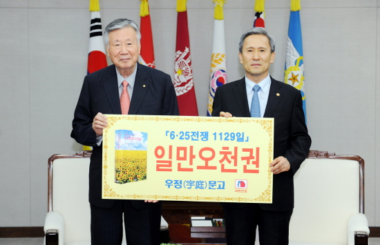 사진= 부영그룹 이중근 회장(좌측)이 김관진 국방부 장관(우측)에 자신의 저서인 &lsquo;6&middot;25전쟁 1129일&rsquo; 1만5000권을 국방부에 기증했다. ⓒ부영그룹