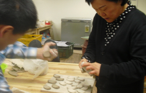  도예품 제작 장면. 우측에서 박미순 서울시립뇌성마비복지관 팀장이 돕고 있다. = 정수지 기자