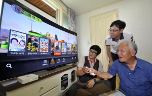 UHD 셋톱박스 1호 가입자 강수원(오른쪽)씨가 B tv를 시청하고 있다. ⓒ SK브로드밴드