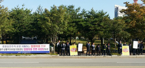  광주교통약자이동지원센타 노조원 20여명이 13일 오전 '광주교통약자이동지원센터 임용채용 전면 재검토하라' 는 현수막을 내걸고 시청 앞에서 시위를 벌이고 있다.=문승용 기자
